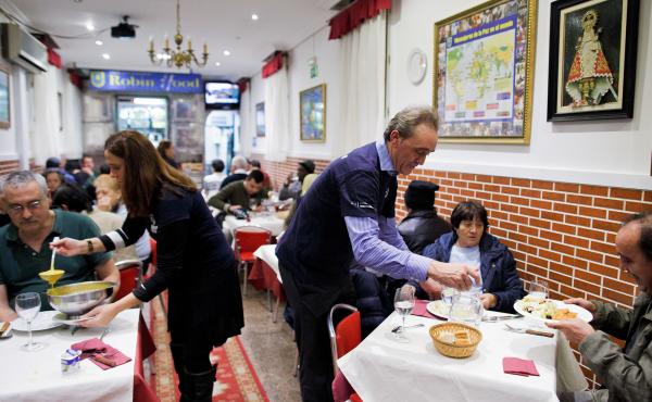 Volunteers serve free dinner to homeless people at Robin Hood restaurant in Madrid. Volunteers serve free dinner to homeless people at Robin Hood restaurant in Madrid.