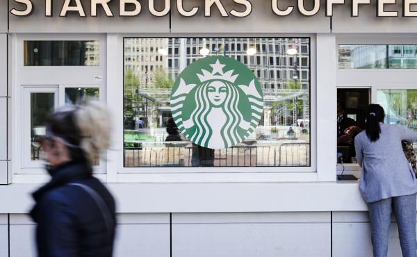 A customer makes a purchase at a Starbucks coffee shop. A customer makes a purchase at a Starbucks coffee shop.