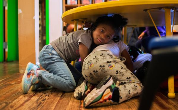 Justice Buress, 4, hides under a table while demonstrating a drill at Little Explorers Learning Center in St. Louis. Tess Trice, head of the day care program, carries out monthly drills to train the children to get on the floor when they hear gunfire. Justice Buress, 4, hides under a table while demonstrating a drill at Little Explorers Learning Center in St. Louis. Tess Trice, head of the day care program, carries out monthly drills to train the children to get on the floor when they hear gunfire.