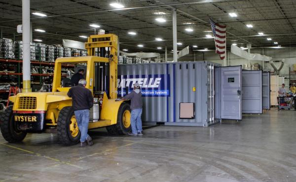Workers inside a warehouse in Columbus, Ohio, prepare Battelle's decontamination units for deployment. Workers inside a warehouse in Columbus, Ohio, prepare Battelle's decontamination units for deployment.