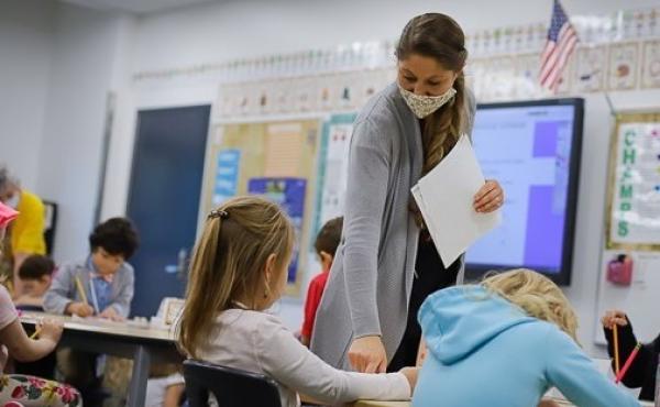 Public school teacher Kelly Mrozik holds in-person class for first graders in Wasilla, Alaska. She is required to wear a mask. Her students are not. Public school teacher Kelly Mrozik holds in-person class for first graders in Wasilla, Alaska. She is required to wear a mask. Her students are not.