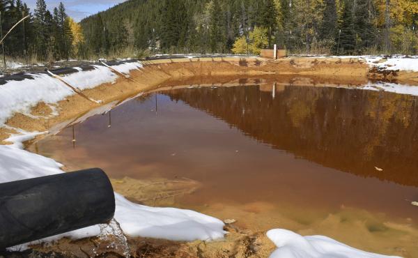 At the Upper Tenmile Creek Mining Area Superfund site in 2018, water contaminated with arsenic, lead and zinc flows from a pipe out of the Lee Mountain mine and into a holding pond near Rimini, Mont. At the Upper Tenmile Creek Mining Area Superfund site in 2018, water contaminated with arsenic, lead and zinc flows from a pipe out of the Lee Mountain mine and into a holding pond near Rimini, Mont.