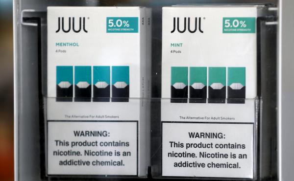 Packages of Juul mint-flavored e-cigarettes are displayed at a smoke shop in 2019. Packages of Juul mint-flavored e-cigarettes are displayed at a smoke shop in 2019.
