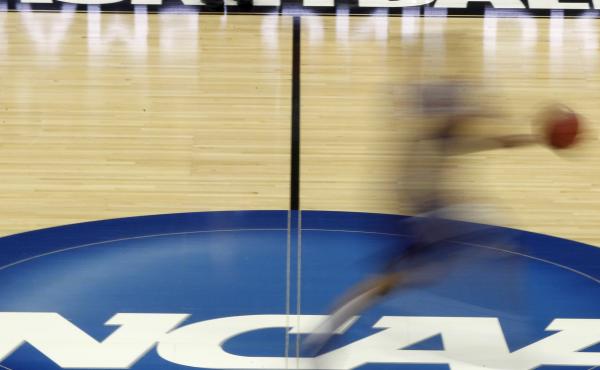 A player streaks across the NCAA logo at midcourt during basketball practice in this file photo from March 14, 2012. A player streaks across the NCAA logo at midcourt during basketball practice in this file photo from March 14, 2012.