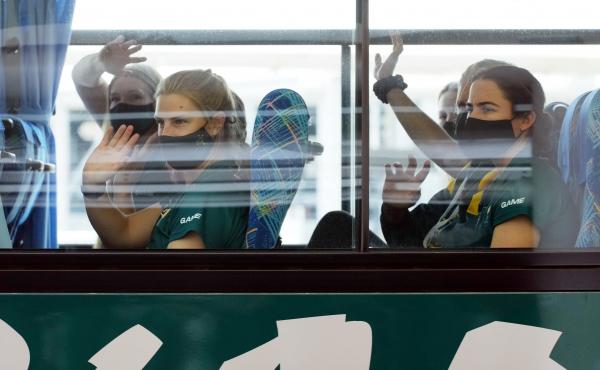 Australian softball players, the first foreign team to arrive for the Tokyo Olympic Games, wave from their bus after arriving at Narita International Airport on June 1. Australian softball players, the first foreign team to arrive for the Tokyo Olympic Games, wave from their bus after arriving at Narita International Airport on June 1.