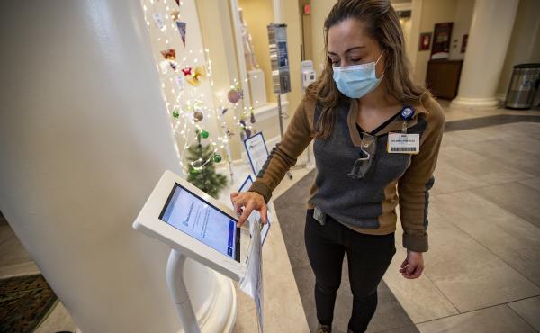 Interpreter Ana Maria Rios-Velez demonstrates the screening app at the front entrance of Brigham and Womens Hospital in Boston. It has a multilingual function to better communicate with non-English speaking patients and staff. Interpreter Ana Maria Rios-Velez demonstrates the screening app at the front entrance of Brigham and Womens Hospital in Boston. It has a multilingual function to better communicate with non-English speaking patients and staff.