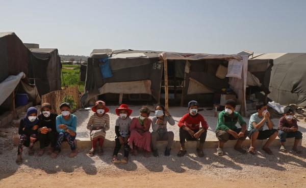 Children displaced by the war in Syria's Idlib province sit, wearing face masks during a COVID-19 awareness campaign this week in Dana. The World Food Programme warned that people living in displaced-person camps could be "particularly vulnerable" to the Children displaced by the war in Syria's Idlib province sit, wearing face masks during a COVID-19 awareness campaign this week in Dana. The World Food Programme warned that people living in displaced-person camps could be "particularly vulnerable" to the