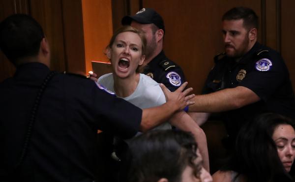 A protester is led away by police after disrupting the second day of the confirmation hearing for Supreme Court nominee Judge Brett Kavanaugh on Capitol Hill. A protester is led away by police after disrupting the second day of the confirmation hearing for Supreme Court nominee Judge Brett Kavanaugh on Capitol Hill.