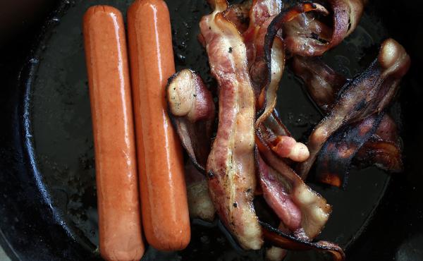 Processed meats, including hot dogs and bacon, cook in a frying pan. A new study of 80,000 people finds that those who ate the most red meat — especially processed meats such as bacon and hot dogs — had a higher risk of premature death compared with t Processed meats, including hot dogs and bacon, cook in a frying pan. A new study of 80,000 people finds that those who ate the most red meat — especially processed meats such as bacon and hot dogs — had a higher risk of premature death compared with t