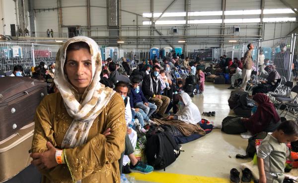 Afghan evacuees wait for the next flight to the U.S. in a fenced-in enclosure in a hangar at Ramstein Air Base in Germany. More than 25,000 Afghans have traveled through Ramstein to get to the United States. Afghan evacuees wait for the next flight to the U.S. in a fenced-in enclosure in a hangar at Ramstein Air Base in Germany. More than 25,000 Afghans have traveled through Ramstein to get to the United States.