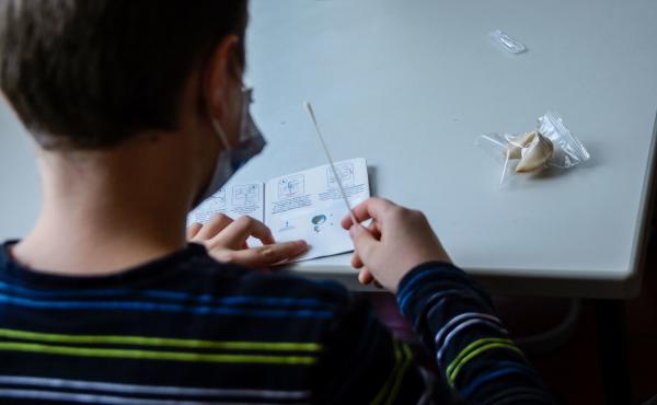 A pupil wearing a face mask reads instructions for a coronavirus rapid test kit at the start of a lesson at an elementary school in Berlin on August 9, 2021. A pupil wearing a face mask reads instructions for a coronavirus rapid test kit at the start of a lesson at an elementary school in Berlin on August 9, 2021.