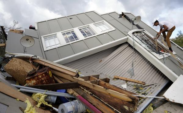 Jeremy Hodges climbs up the side of his family's destroyed storage unit on Monday, in Houma, La., which sits just along the coast of Louisiana. Jeremy Hodges climbs up the side of his family's destroyed storage unit on Monday, in Houma, La., which sits just along the coast of Louisiana.