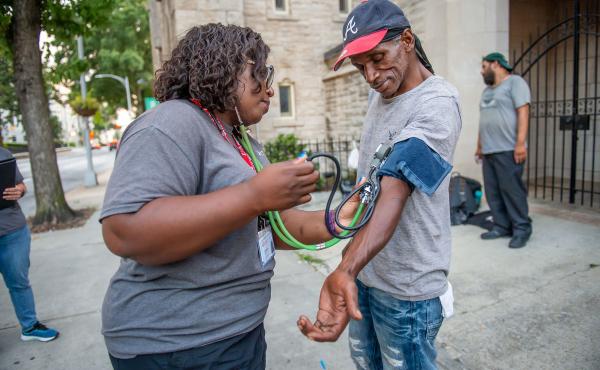 Licensed practical nurse Stephanie Dotson measures Kent Beasley's blood pressure in downtown Atlanta in September. Dotson is a member of the Mercy Care team that works to bring medical care to Atlanta residents who are homeless. Licensed practical nurse Stephanie Dotson measures Kent Beasley's blood pressure in downtown Atlanta in September. Dotson is a member of the Mercy Care team that works to bring medical care to Atlanta residents who are homeless.
