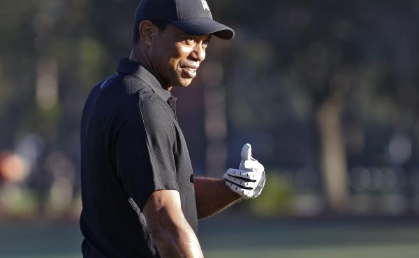 Tiger Woods smiles and gestures as he prepares to tee off during the first round of the PNC Championship golf tournament Friday in Orlando, Fla. Woods is back playing after getting injured in a car accident. He is paired with his son Charlie during the to Tiger Woods smiles and gestures as he prepares to tee off during the first round of the PNC Championship golf tournament Friday in Orlando, Fla. Woods is back playing after getting injured in a car accident. He is paired with his son Charlie during the to