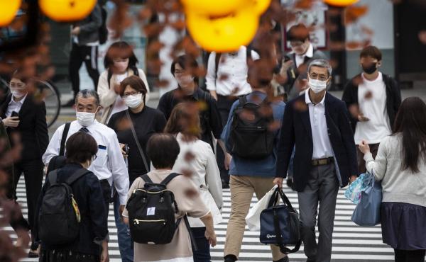 People in Tokyo wear masks on May 7. Daily coronavirus infections in Japan's capital have topped 4,000 — nearly four times as many as a week ago. People in Tokyo wear masks on May 7. Daily coronavirus infections in Japan's capital have topped 4,000 — nearly four times as many as a week ago.