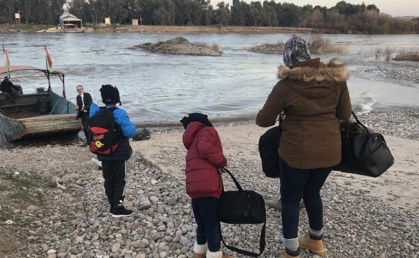 Mahmud, 11, Ayyub, 7, and their mother, Felicia Perkins-Ferreira, walk toward the boat that will take them out of Syria, across the river to Iraq, so they can start their journey home to Trinidad. Mahmud, 11, Ayyub, 7, and their mother, Felicia Perkins-Ferreira, walk toward the boat that will take them out of Syria, across the river to Iraq, so they can start their journey home to Trinidad.