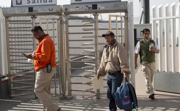 Carlos Catarldo Gomez, of Honduras, center, is escorted by Mexican officials after leaving the United States, the first person returned to Mexico to wait for his asylum trial date, in Tijuana, Mexico Carlos Catarldo Gomez, of Honduras, center, is escorted by Mexican officials after leaving the United States, the first person returned to Mexico to wait for his asylum trial date, in Tijuana, Mexico