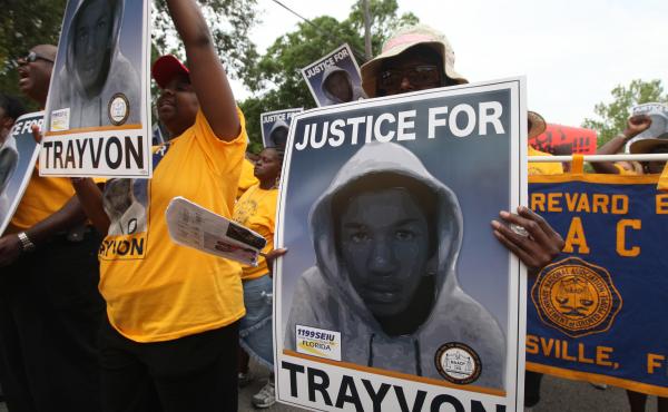 Protesters hold up signs at a march and rally for slain Florida teenager Trayvon Martin in Sanford, Fla., on March 31, 2012. Protesters hold up signs at a march and rally for slain Florida teenager Trayvon Martin in Sanford, Fla., on March 31, 2012.