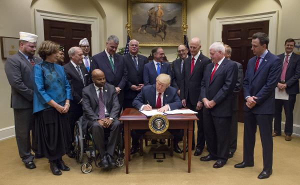 President Donald Trump signs the Veterans Choice Program Extension and Improvement Act at the White House on Wednesday. President Donald Trump signs the Veterans Choice Program Extension and Improvement Act at the White House on Wednesday.