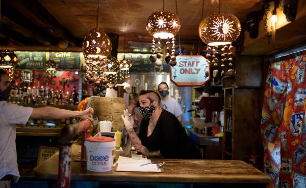 A bartender wearing a face mask and gloves checks a patron's ID at Under the Volcano in Houston last month. Texas is one of the states seeing a big uptick in coronavirus cases and hospitalizations. A bartender wearing a face mask and gloves checks a patron's ID at Under the Volcano in Houston last month. Texas is one of the states seeing a big uptick in coronavirus cases and hospitalizations.