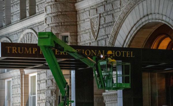A worker removes the signage for the Trump International Hotel on Wednesday, in Washington. A worker removes the signage for the Trump International Hotel on Wednesday, in Washington.