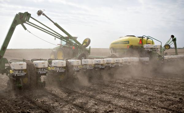 A tractor pulls a planter while distributing corn seed on a field in Malden, Ill. Two scientists agree that pesticide-laden dust from planting equipment kills bees. But they're proposing different solutions, because they disagree about whether the pestici A tractor pulls a planter while distributing corn seed on a field in Malden, Ill. Two scientists agree that pesticide-laden dust from planting equipment kills bees. But they're proposing different solutions, because they disagree about whether the pestici
