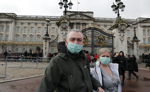 A couple wear face masks as they visit Buckingham Palace in London on Saturday. After criticism for responding slowly, the United Kingdom has urged the public to avoid unnecessary contact. A couple wear face masks as they visit Buckingham Palace in London on Saturday. After criticism for responding slowly, the United Kingdom has urged the public to avoid unnecessary contact.