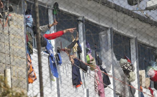 Inmates point from inside the La Modelo facility in Bogotá, Colombia, on Sunday. Violence broke out in the prison out of inmates' fears that prison guards are not doing enough to prevent coronavirus inside overcrowded prisons. Inmates point from inside the La Modelo facility in Bogotá, Colombia, on Sunday. Violence broke out in the prison out of inmates' fears that prison guards are not doing enough to prevent coronavirus inside overcrowded prisons.
