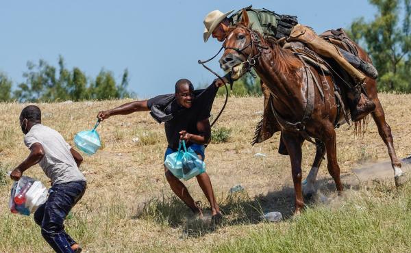 A U.S. Border Patrol agent on horseback tries to stop a Haitian migrant from entering an encampment on the banks of the Rio Grande on Sunday near the international bridge in Del Rio, Texas. A U.S. Border Patrol agent on horseback tries to stop a Haitian migrant from entering an encampment on the banks of the Rio Grande on Sunday near the international bridge in Del Rio, Texas.