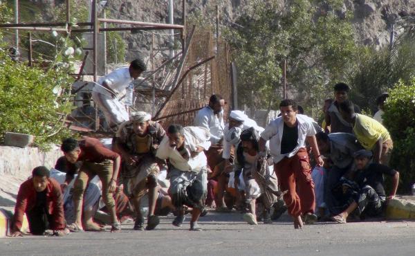 People seek shelter amid gunfire at an army base in Yemen's southern port city of Aden on Wednesday. People seek shelter amid gunfire at an army base in Yemen's southern port city of Aden on Wednesday.