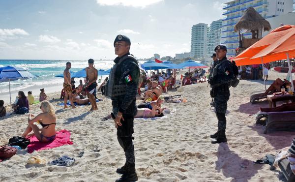 Mexican federal police patrol a beach in Cancun earlier this year, after a shooting at a local nightclub the day before. Mexican federal police patrol a beach in Cancun earlier this year, after a shooting at a local nightclub the day before.