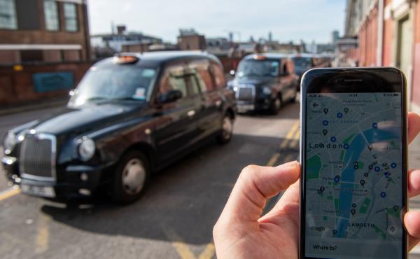 A phone shows the Uber app in front of a taxi stand at Waterloo station in London on Monday. The ride-sharing service won its appeal after Transport for London denied a renewal of its operating license late last year. A phone shows the Uber app in front of a taxi stand at Waterloo station in London on Monday. The ride-sharing service won its appeal after Transport for London denied a renewal of its operating license late last year.