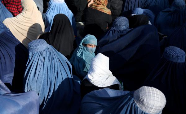 A girl sits in front of a bakery in the crowd with Afghan women waiting to receive bread in Kabul on Jan. 31, 2022. A girl sits in front of a bakery in the crowd with Afghan women waiting to receive bread in Kabul on Jan. 31, 2022.