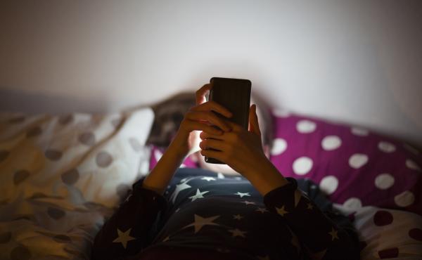 A child uses a cell phone. A child uses a cell phone.