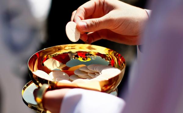 A priest holds a Holy Communion wafer in Washington, D.C. A priest holds a Holy Communion wafer in Washington, D.C.