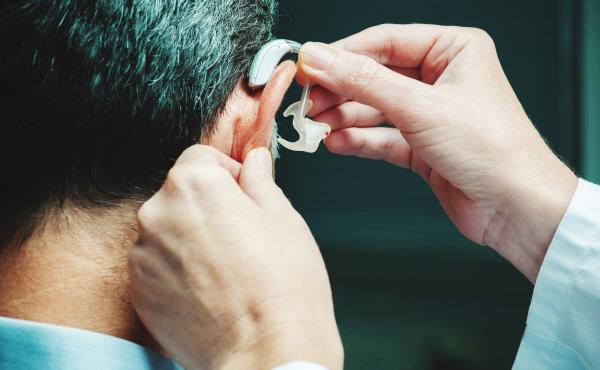 A man gets his hearing aid adjusted. Two large studies show that age-related memory loss can be slowed when older people promptly address hearing and vision loss. A man gets his hearing aid adjusted. Two large studies show that age-related memory loss can be slowed when older people promptly address hearing and vision loss.
