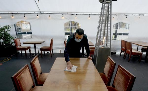 A person cleans a table in an outdoor tented dining area of a restaurant in Sacramento, Calif., on Nov. 19. Job growth slowed sharply in November as relief aid is due to expire at the end of the year. A person cleans a table in an outdoor tented dining area of a restaurant in Sacramento, Calif., on Nov. 19. Job growth slowed sharply in November as relief aid is due to expire at the end of the year.