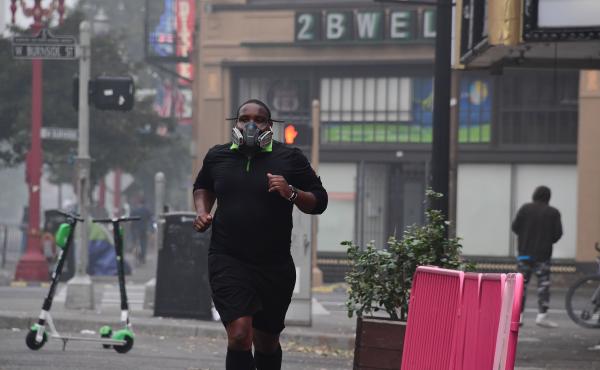 A Portland, Ore., resident wears a respirator to protect himself from wildfire smoke as he jogs in downtown in September 2020. A Portland, Ore., resident wears a respirator to protect himself from wildfire smoke as he jogs in downtown in September 2020.