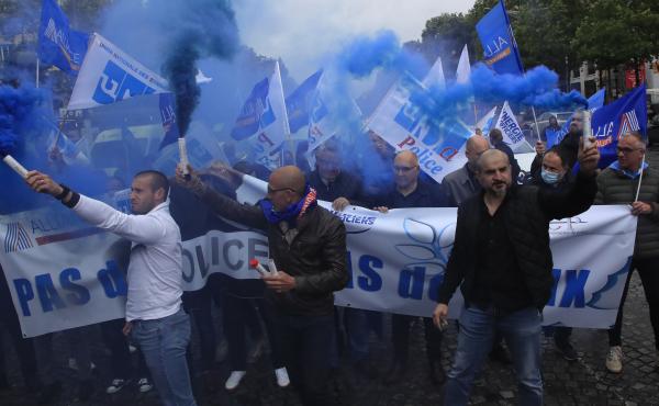 French police unionists fire blue flares as they demonstrate with a banner reading" No police, no peace" down the Champs-Élysées in Paris on Friday. French police unionists fire blue flares as they demonstrate with a banner reading" No police, no peace" down the Champs-Élysées in Paris on Friday.