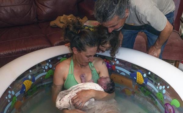 Morgan Cooper holds newborn Lourice as her husband Saleh Totah and 4-year-old son look on. Lourice was delivered in June in a home birth in an inflatable swimming pool in the family's home in the West Bank city of Ramallah. They planned to travel to the U Morgan Cooper holds newborn Lourice as her husband Saleh Totah and 4-year-old son look on. Lourice was delivered in June in a home birth in an inflatable swimming pool in the family's home in the West Bank city of Ramallah. They planned to travel to the U