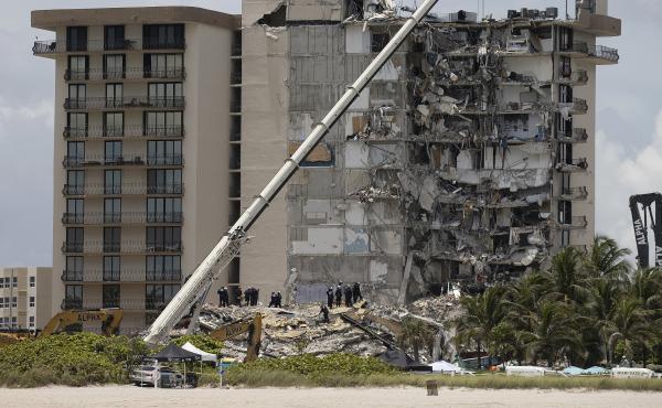 Members of the South Florida Urban Search and Rescue team look for survivors in the partially collapsed 12-story Champlain Towers South condo building in Surfside, Fla., on June 26. Members of the South Florida Urban Search and Rescue team look for survivors in the partially collapsed 12-story Champlain Towers South condo building in Surfside, Fla., on June 26.