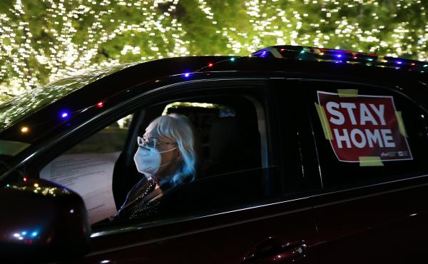 A "Stay Home" sign is taped to a driver's vehicle as she passes Christmas lights during a car caravan of nurses calling for people to remain home amid a coronavirus surge last month in El Paso, Texas. A "Stay Home" sign is taped to a driver's vehicle as she passes Christmas lights during a car caravan of nurses calling for people to remain home amid a coronavirus surge last month in El Paso, Texas.