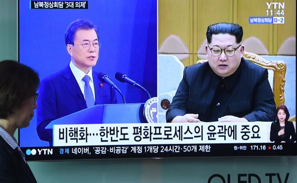 A woman walks past a news screen showing file footage of South Korean President Moon Jae-in and North Korean leader Kim Jong Un at a railway station in Seoul this week. Kim will walk across the Demilitarized Zone on Friday for a historic summit with Moon. A woman walks past a news screen showing file footage of South Korean President Moon Jae-in and North Korean leader Kim Jong Un at a railway station in Seoul this week. Kim will walk across the Demilitarized Zone on Friday for a historic summit with Moon.