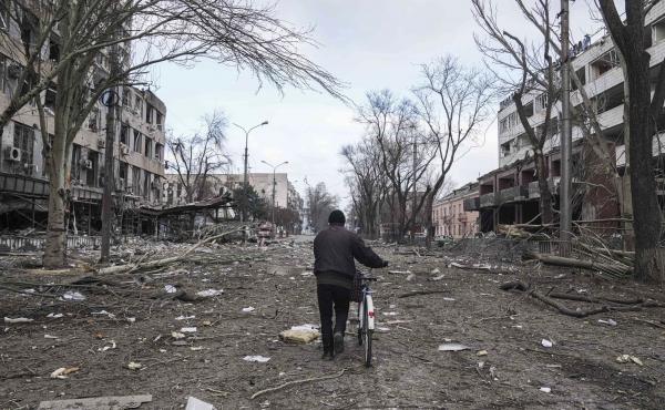 A man walks with a bicycle on a street damaged by shelling in Mariupol, Ukraine, earlier this month. A man walks with a bicycle on a street damaged by shelling in Mariupol, Ukraine, earlier this month.