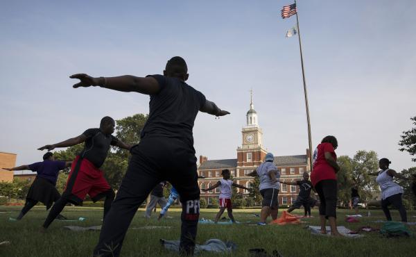 Participants stretch during a "yoga on the yard" class, one of Howard University's sesquicentennial celebration events that was open to anyone who wanted to attend in Washington, D.C. The university is trying to foster better communication with the surrou Participants stretch during a "yoga on the yard" class, one of Howard University's sesquicentennial celebration events that was open to anyone who wanted to attend in Washington, D.C. The university is trying to foster better communication with the surrou