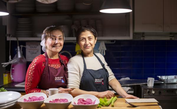 Two Syrian refugees, Narwal Alakayleh (left) and Lina AlAlssantin (right), prepare for a pop-up dinner of Levantine food at Newcomer Kitchen. Two Syrian refugees, Narwal Alakayleh (left) and Lina AlAlssantin (right), prepare for a pop-up dinner of Levantine food at Newcomer Kitchen.
