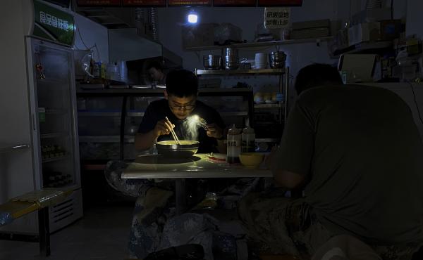 A man uses his smartphone flashlight to light up his bowl of noodles as he eats breakfast at a restaurant during a blackout in Shenyang, in northeastern China's Liaoning province, Wednesday. People ate breakfast by flashlight and shopkeepers used portable A man uses his smartphone flashlight to light up his bowl of noodles as he eats breakfast at a restaurant during a blackout in Shenyang, in northeastern China's Liaoning province, Wednesday. People ate breakfast by flashlight and shopkeepers used portable