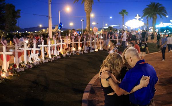 A small group prays at a makeshift memorial for victims of the Las Vegas massacre. A small group prays at a makeshift memorial for victims of the Las Vegas massacre.