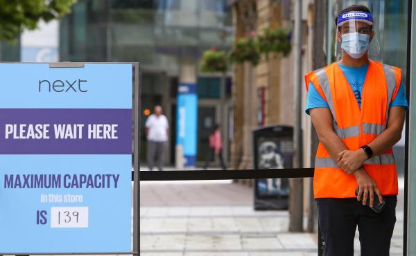 A retail worker wears a face mask and face shield as a precautionary measure during the coronavirus pandemic. A retail worker wears a face mask and face shield as a precautionary measure during the coronavirus pandemic.