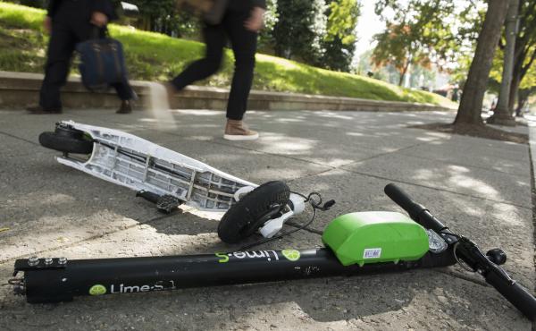 A broken Lime electric scooter lays on a sidewalk in Washington, D.C. A broken Lime electric scooter lays on a sidewalk in Washington, D.C.